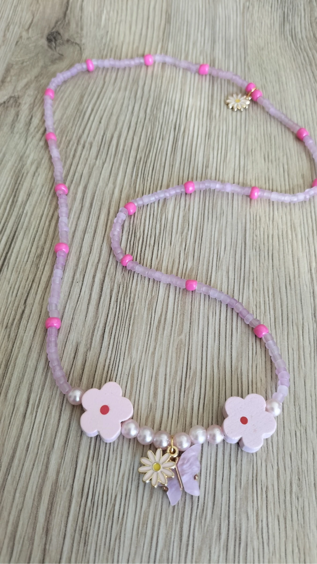 Collier à perles avec charm papillon et fleur 